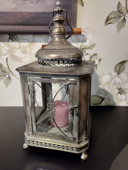 Vacker lykta som passar perfekt för att skapa en romantisk och mysig stämning i ditt hem.  Hållare för värmeljus följer med.  Mått: 22x50cm  Färg: Antik Brun  Material: Metall/Glas