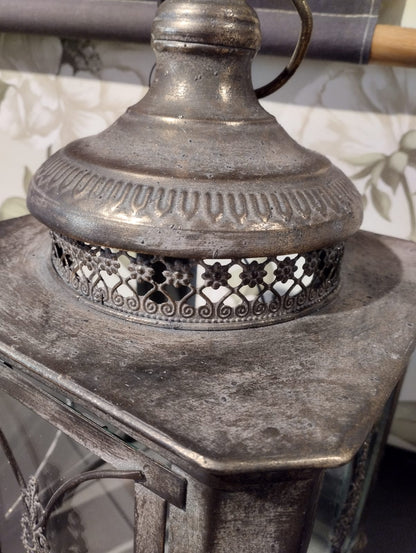 Vacker lykta som passar perfekt för att skapa en romantisk och mysig stämning i ditt hem.  Hållare för värmeljus följer med.  Mått: 22x50cm  Färg: Antik Brun  Material: Metall/Glas