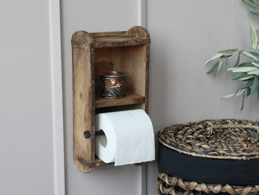 Rustik toalettpappershållare som är tillverkad av en gammal murstensform. Det finns en liten hylla. Passar bra för en vanlig toalettpappersrulle.  Mått: H 30cm, L 15cm, B 10cm  Material: Trä. OBS: Detta är en unik produkt, storlek och utseende kan variera lite. Metallbeslag kan fattas vilket gör att de ser naturligt slitna ut. Det kan även förekomma sprickor i träskivorna.