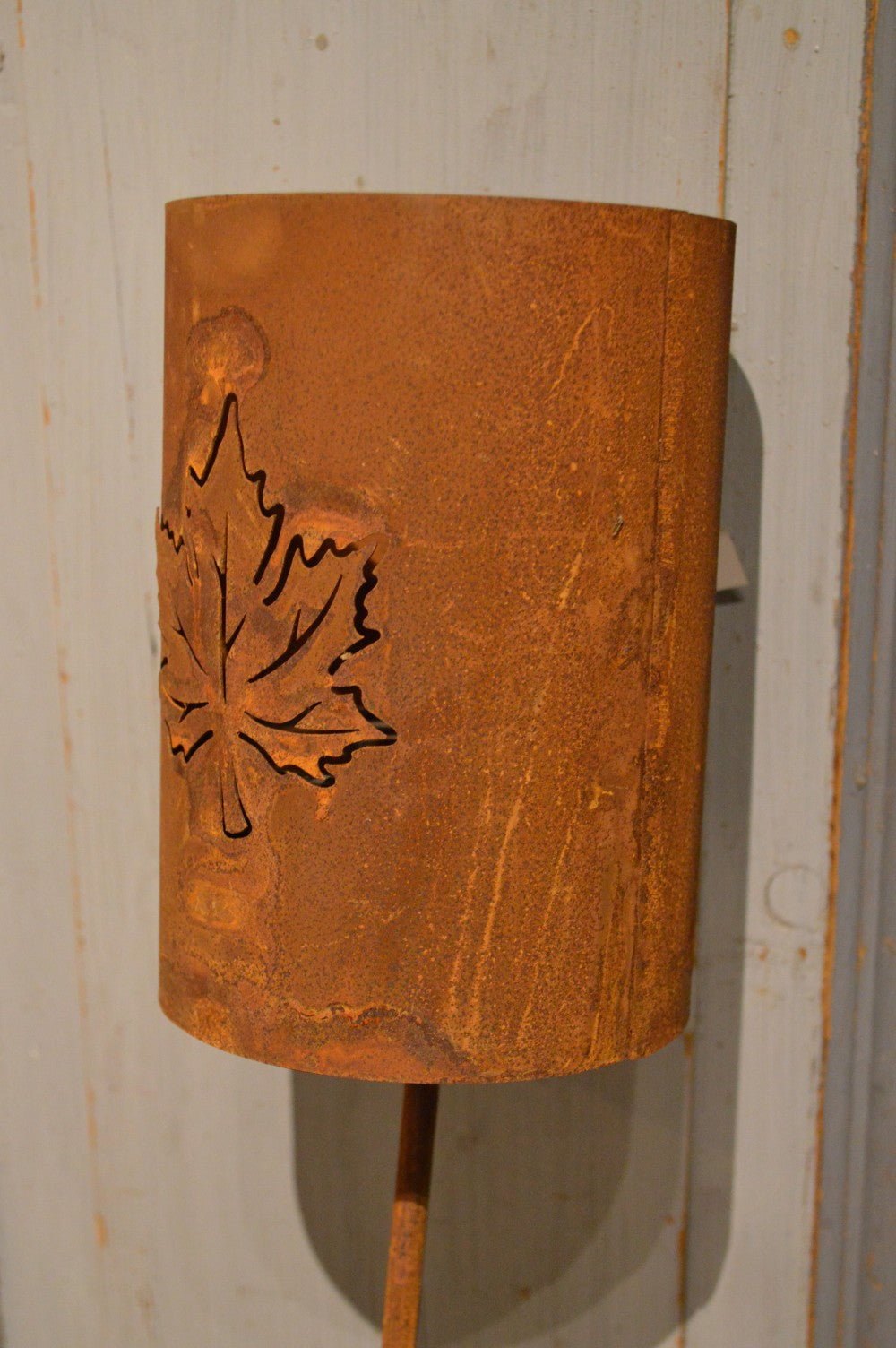 Marschallhållare med utskurna löv på båda sidor, med delbar stav och markfäste. Går utmärkt att sätta en blomma i den också.  Material: Rostig plåt  Storlek: ca 12 x 17 x 114 cm  OBS: Ljus ingår ej. Staven och hållare skruvas ihop.